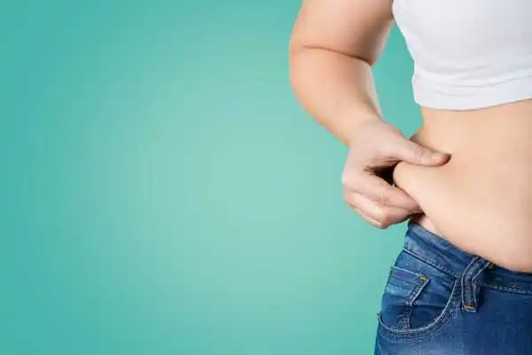 Image of woman pinching her love handles to show weight gain Purfleet